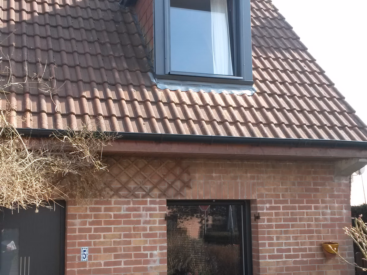 Lucarne chien assis anthracite sur maison en briques du Nord